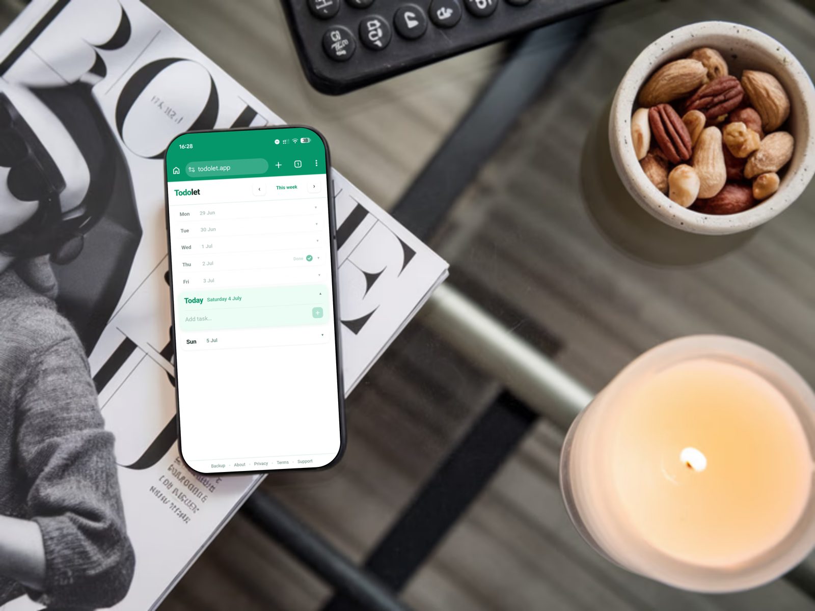 Todolet on a phone on a coffee table with a candle and bowl of nuts